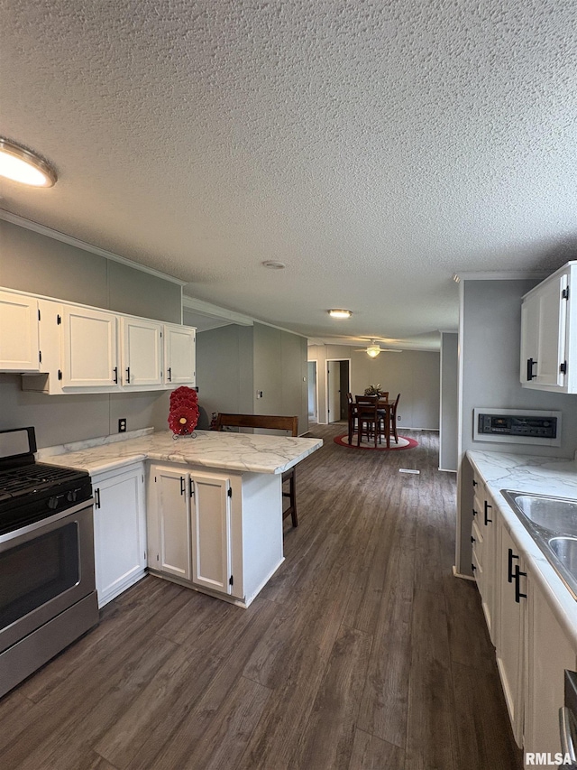 715 Wastena St, Benton, IL 62812 - kitchen featuring gas stove, a textured ceiling, dark wood-type flooring, a peninsula, and white cabinetry