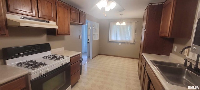 2903 Logan St, Mount Vernon, IL 62864 - kitchen featuring white gas stove, under cabinet range hood, light flooring, light countertops, and a ceiling fan