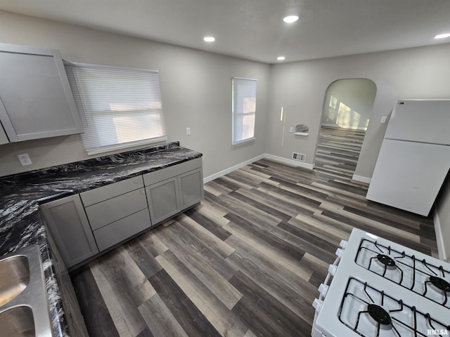 832 Fairfield Rd, Mount Vernon, IL 62864 - kitchen featuring white appliances, recessed lighting, gray cabinetry, dark wood finished floors, and arched walkways