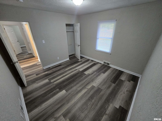 832 Fairfield Rd, Mount Vernon, IL 62864 - unfurnished bedroom with a textured wall, wood finished floors, a closet, and a textured ceiling