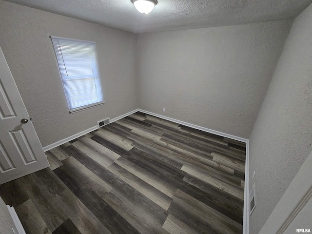 832 Fairfield Rd, Mount Vernon, IL 62864 - empty room with a textured wall, dark wood finished floors, and a textured ceiling