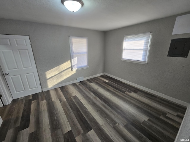 832 Fairfield Rd, Mount Vernon, IL 62864 - unfurnished room with electric panel, a textured wall, and dark wood-style flooring