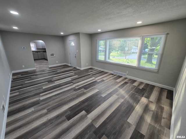 832 Fairfield Rd, Mount Vernon, IL 62864 - unfurnished living room featuring arched walkways, recessed lighting, wood finished floors, and a textured ceiling