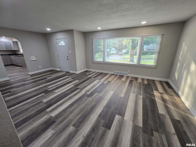 832 Fairfield Rd, Mount Vernon, IL 62864 - unfurnished living room with arched walkways, dark wood finished floors, recessed lighting, and a textured ceiling