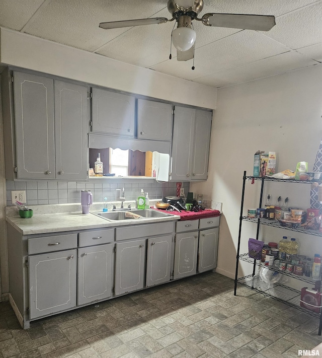 123 W College St, Harrisburg, IL 62946 - kitchen with gray cabinets, a ceiling fan, tasteful backsplash, brick patterned floors, and light countertops