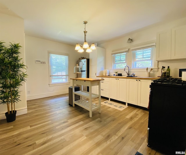 245 W Mcclernand Ave, Shawneetown, IL 62984 - kitchen with gas stove, a chandelier, light wood-style flooring, and freestanding refrigerator