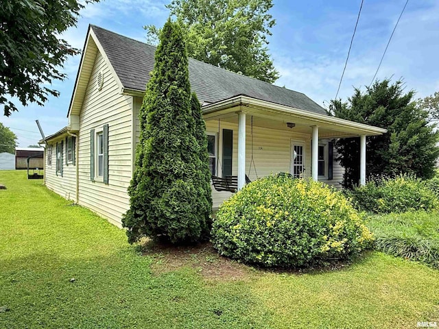 104 E 5th St, Brookport, IL 62910 - view of side of home with a yard, a shingled roof, and covered porch