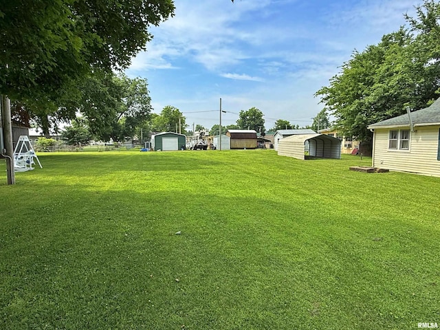 104 E 5th St, Brookport, IL 62910 - view of green lawn featuring a detached carport and an outbuilding
