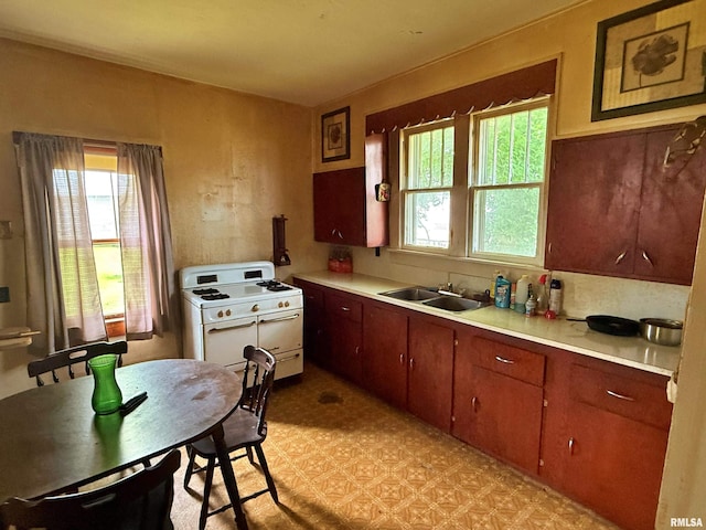 104 E 5th St, Brookport, IL 62910 - kitchen featuring white gas range, plenty of natural light, light floors, and light countertops