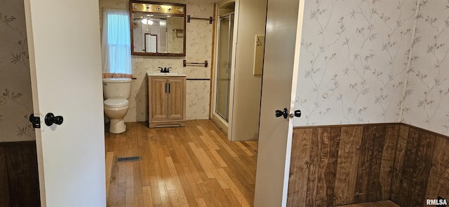 45 Donetta Ln, Creal Springs, IL 62922 - full bath with wallpapered walls, wood-type flooring, vanity, a stall shower, and a wainscoted wall
