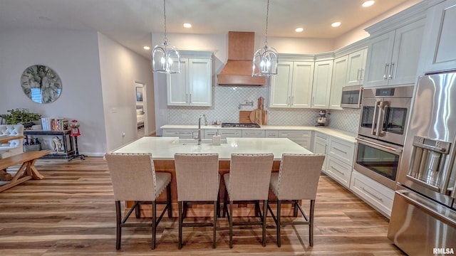 2940 Parrish Rdg, Goreville, IL 62939 - kitchen featuring appliances with stainless steel finishes, premium range hood, wood finished floors, a kitchen breakfast bar, and recessed lighting