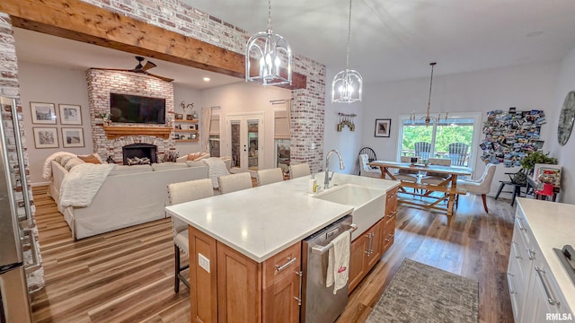 2940 Parrish Rdg, Goreville, IL 62939 - kitchen featuring stainless steel dishwasher, light wood-type flooring, a fireplace, light countertops, and beam ceiling