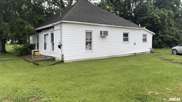 404 E Main St, Buckner, IL 62812 - view of side of home featuring roof with shingles, a yard, and an AC wall unit