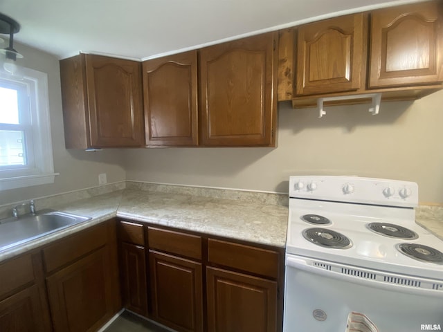 211 Charles St, Benton, IL 62812 - kitchen with white electric range, light countertops, and brown cabinets
