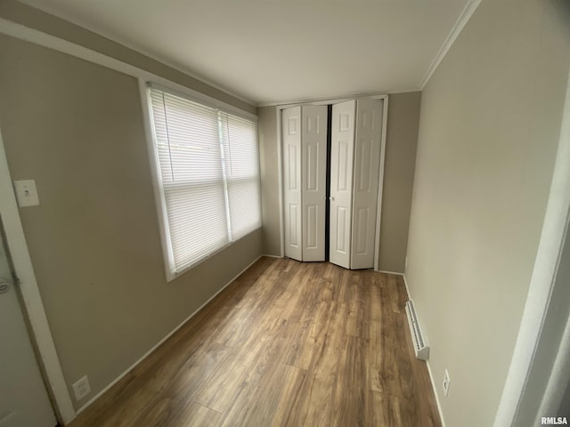 211 Charles St, Benton, IL 62812 - unfurnished bedroom featuring wood finished floors, crown molding, and a closet