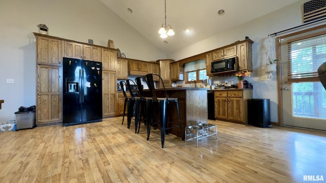 2209 Cedar Hill Rd, West Frankfort, IL 62896 - kitchen with black appliances, light wood-style flooring, plenty of natural light, a kitchen bar, and high vaulted ceiling