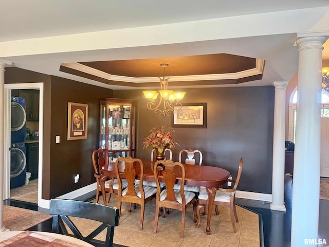 5024 Rosebud Rd, Metropolis, IL 62960 - dining room featuring a tray ceiling, light tile patterned flooring, ornate columns, ornamental molding, and stacked washer and clothes dryer