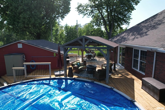 5024 Rosebud Rd, Metropolis, IL 62960 - view of pool featuring a wooden deck, a gazebo, a covered pool, a storage shed, and an outdoor living space with a fire pit
