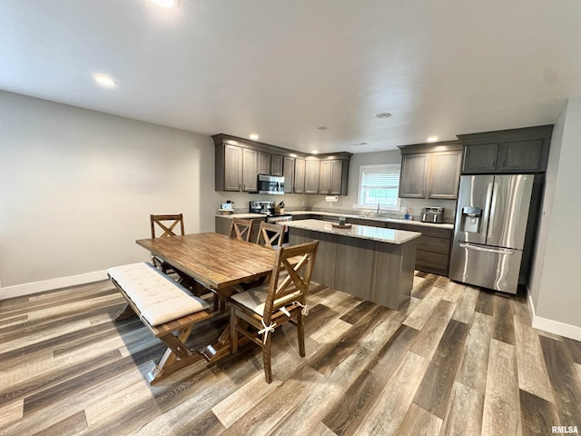 408 Madison St, Cambria, IL 62915 - kitchen with stainless steel appliances, wood finished floors, a kitchen island, recessed lighting, and light stone countertops