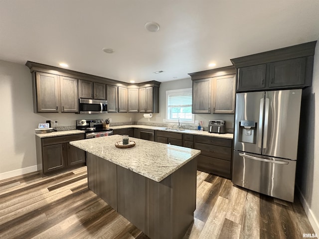 408 Madison St, Cambria, IL 62915 - kitchen with stainless steel appliances, dark wood-style flooring, light stone counters, a center island, and recessed lighting