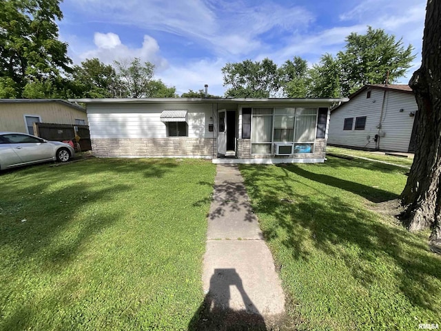 1323 Cedar St, Centralia, IL 62801 - view of front facade featuring stone siding, a front lawn, and a sunroom