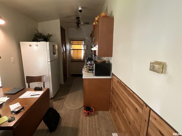 1323 Cedar St, Centralia, IL 62801 - kitchen with freestanding refrigerator, stainless steel microwave, ceiling fan, under cabinet range hood, and brown cabinets