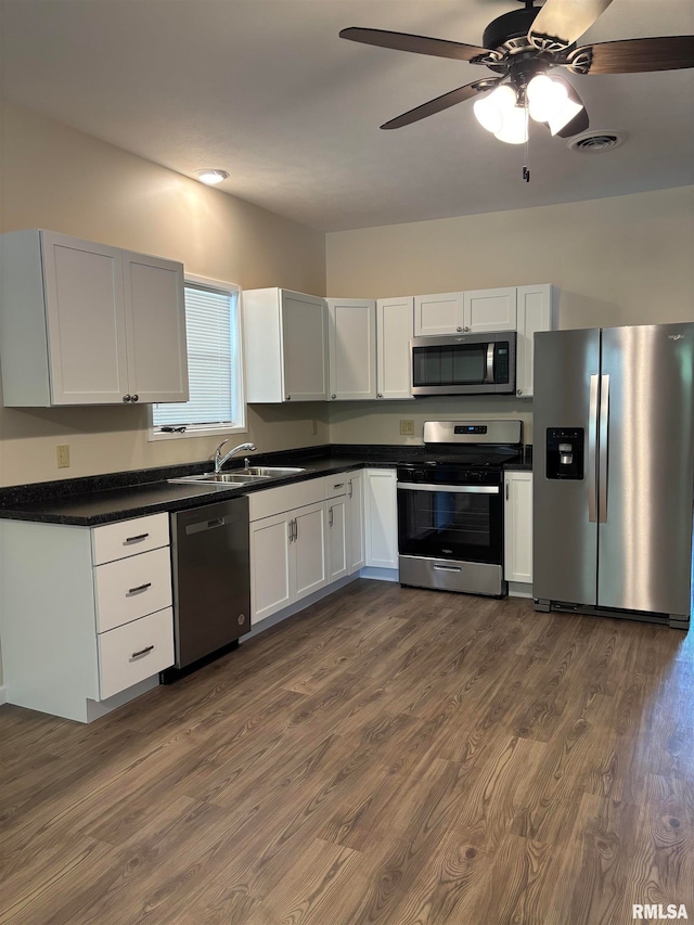 111 Bevard St, Carterville, IL 62918 - kitchen with stainless steel appliances, dark wood-style floors, dark countertops, ceiling fan, and white cabinets