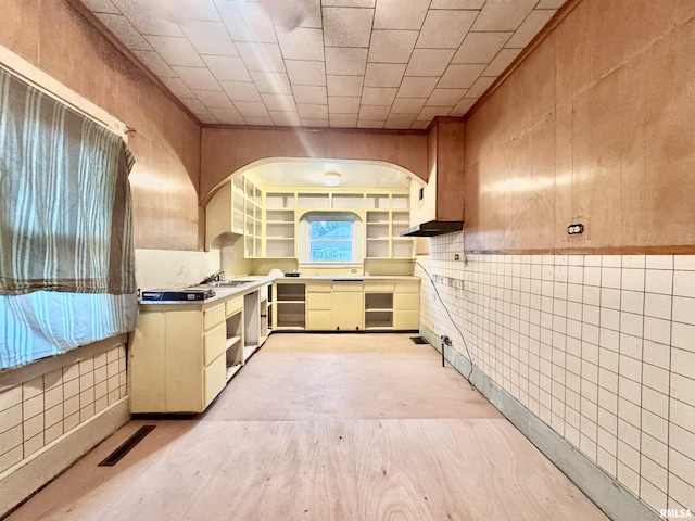 809 Highland St, Benton, IL 62812 - kitchen with arched walkways, exhaust hood, beverage cooler, tile walls, and light wood-type flooring