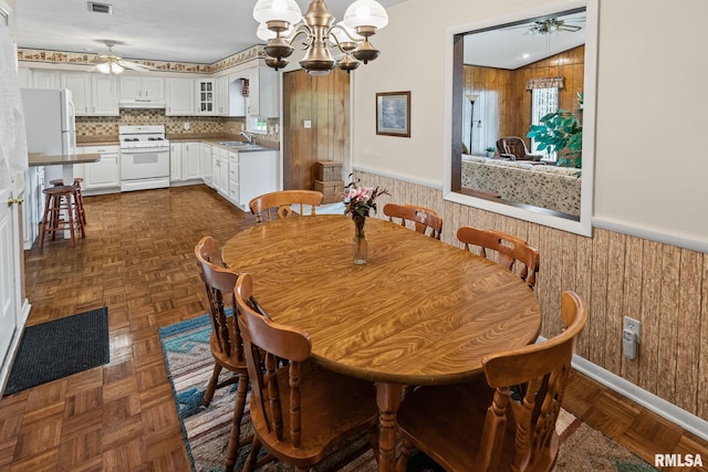 10 Monroe Ave, Salem, IL 62881 - dining room featuring a ceiling fan, a wainscoted wall, a chandelier, and wooden walls