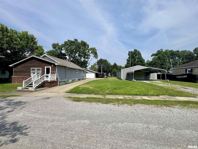 606 N Orchard St, West Frankfort, IL 62896 - view of side of property featuring driveway, a lawn, a detached carport, and an outbuilding