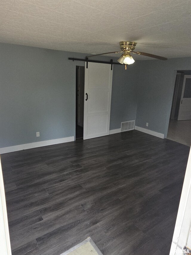 2508 Forest Ave, Mount Vernon, IL 62864 - unfurnished room featuring a barn door, dark wood-style flooring, and a ceiling fan
