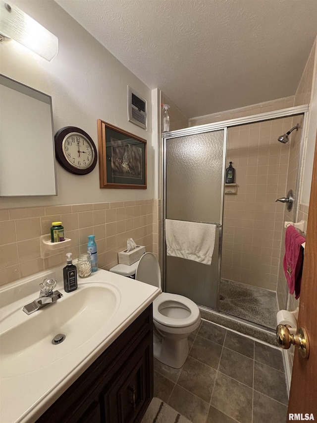 49 Jon St, Metropolis, IL 62960 - bathroom featuring vanity, a shower stall, a textured ceiling, tile patterned flooring, and tile walls