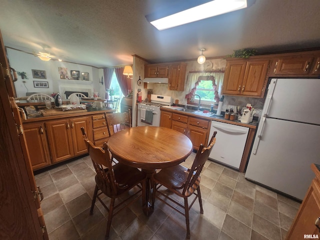 8747 Old State Route 14th Rte, Duquoin, IL 62832 - kitchen featuring white appliances, under cabinet range hood, brown cabinets, a textured ceiling, and backsplash