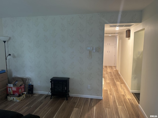 308 Blossom St, Carterville, IL 62918 - unfurnished living room with light wood-style flooring, a wood stove, and wallpapered walls