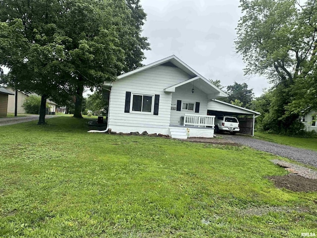 308 Blossom St, Carterville, IL 62918 - view of front of house featuring gravel driveway, an attached carport, and a front yard