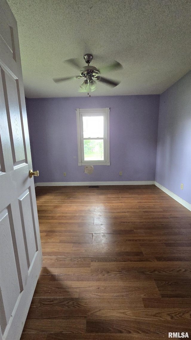 711 Mclean St, Rosiclare, IL 62982 - unfurnished room with wood finished floors, ceiling fan, and a textured ceiling