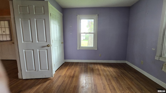 711 Mclean St, Rosiclare, IL 62982 - unfurnished bedroom with dark wood-type flooring and baseboards