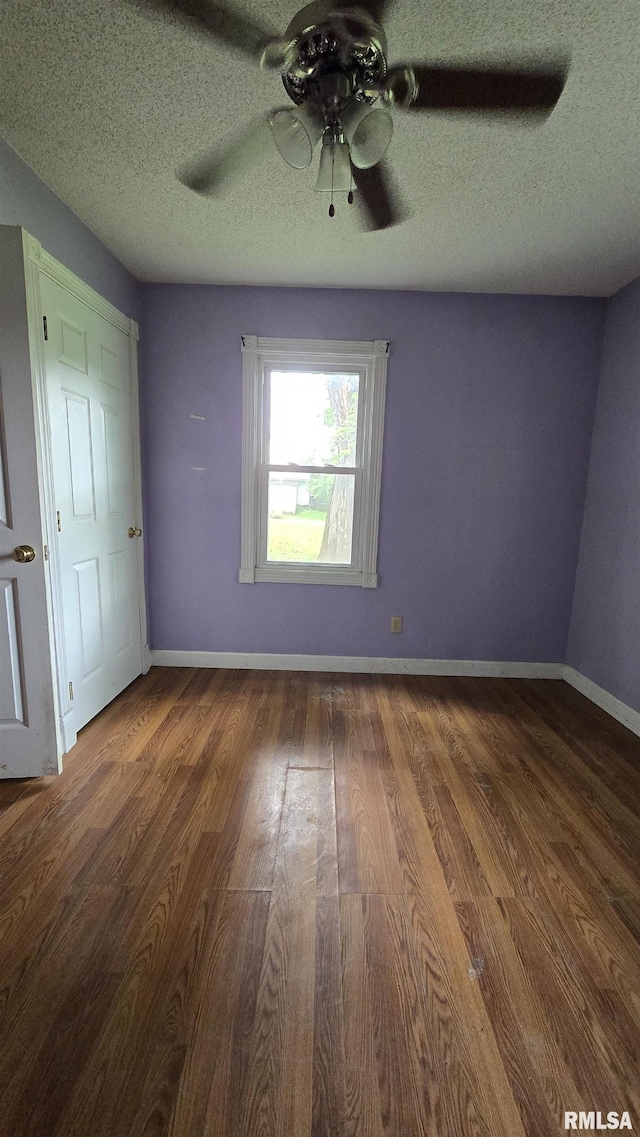 711 Mclean St, Rosiclare, IL 62982 - unfurnished bedroom with wood finished floors, a textured ceiling, and a ceiling fan