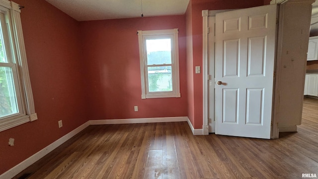 711 Mclean St, Rosiclare, IL 62982 - spare room featuring dark wood-type flooring and baseboards