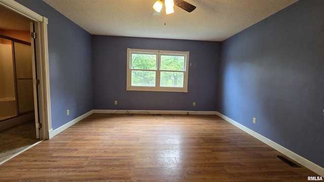 711 Mclean St, Rosiclare, IL 62982 - unfurnished bedroom with a textured ceiling, wood finished floors, and ceiling fan