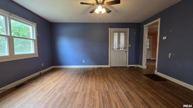 711 Mclean St, Rosiclare, IL 62982 - spare room featuring wood finished floors, ceiling fan, and a textured ceiling