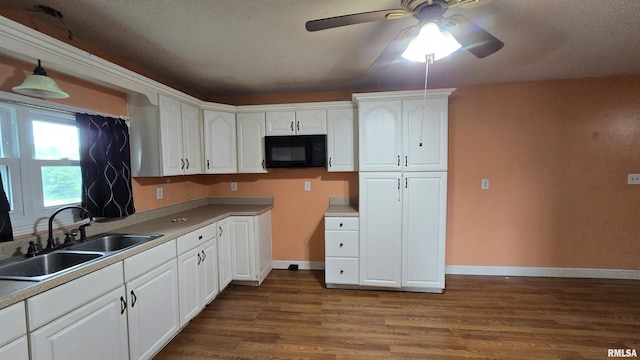 711 Mclean St, Rosiclare, IL 62982 - kitchen featuring black microwave, white cabinets, ceiling fan, dark wood-style flooring, and hanging light fixtures