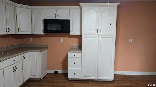 711 Mclean St, Rosiclare, IL 62982 - kitchen with black microwave, dark wood-style flooring, and white cabinetry