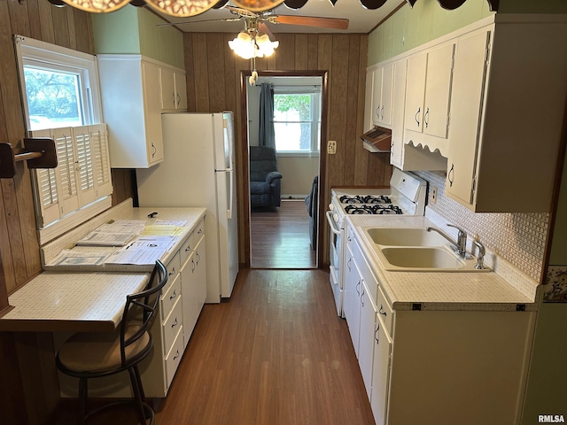 1026 E Noleman St, Centralia, IL 62801 - kitchen with white appliances, light countertops, wood walls, wood finished floors, and ventilation hood