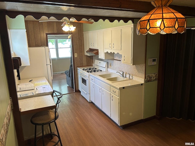 1026 E Noleman St, Centralia, IL 62801 - kitchen with white appliances, range hood, wood finished floors, light countertops, and tasteful backsplash