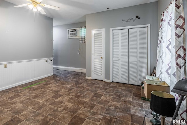 16777 Dublin St, West Frankfort, IL 62896 - interior space with ceiling fan, a wainscoted wall, an AC wall unit, and dark stone finish floors