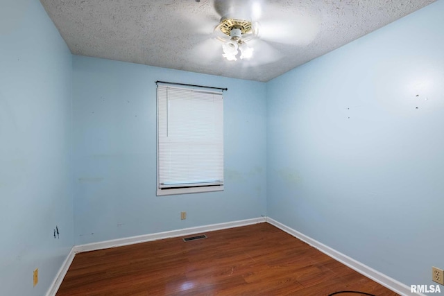 16777 Dublin St, West Frankfort, IL 62896 - empty room featuring a textured ceiling, dark wood finished floors, and ceiling fan