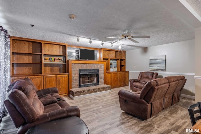 16777 Dublin St, West Frankfort, IL 62896 - living area with a textured ceiling, a ceiling fan, light wood-style floors, and a fireplace