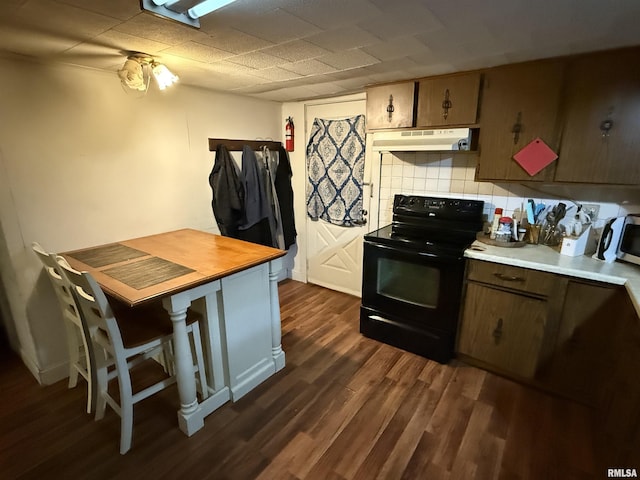 41 Cache Ave, Buncombe, IL 62912 - kitchen with black / electric stove, under cabinet range hood, dark wood finished floors, backsplash, and stainless steel microwave