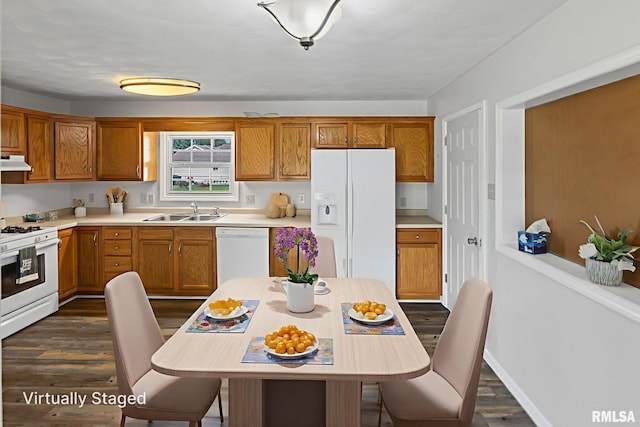326 N Indiana St, Salem, IL 62881 - kitchen with white appliances, dark wood-style flooring, under cabinet range hood, light countertops, and brown cabinets